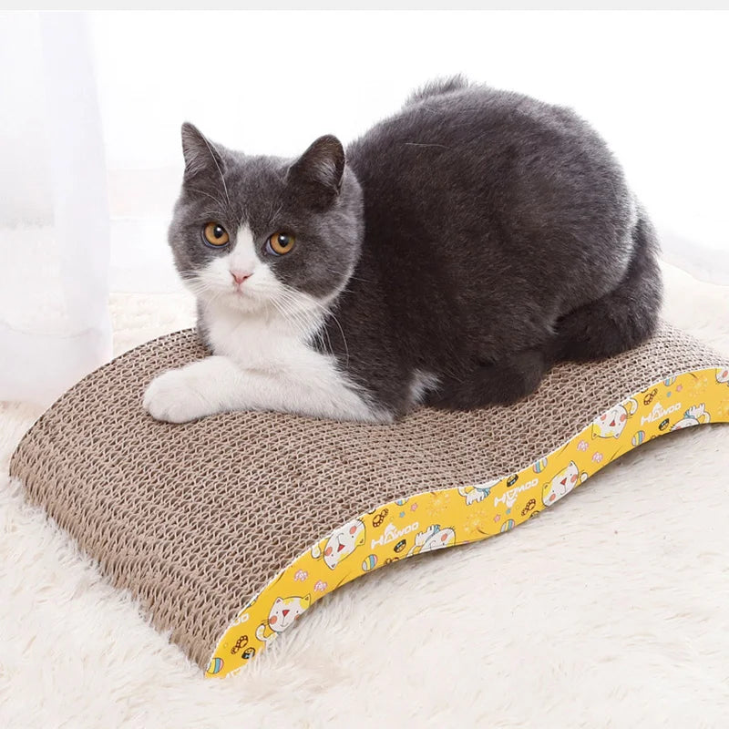 Ein flauschiger grau-weißer Kater ruht auf einer gelb gemusterten Wellblechplatte zum Kratzen.