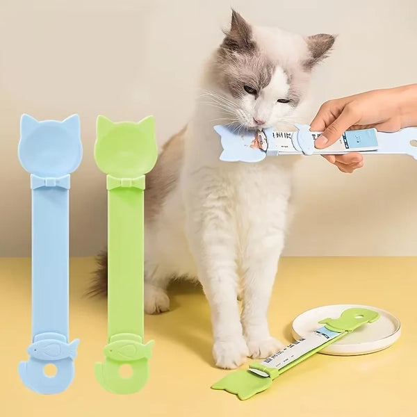 Un gato blanco interactuando con un dispensador de comida húmeda de mango largo, mostrando el diseño del producto.