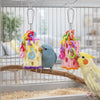 Colorful hanging chewing toys with rings are displayed inside a bird cage.