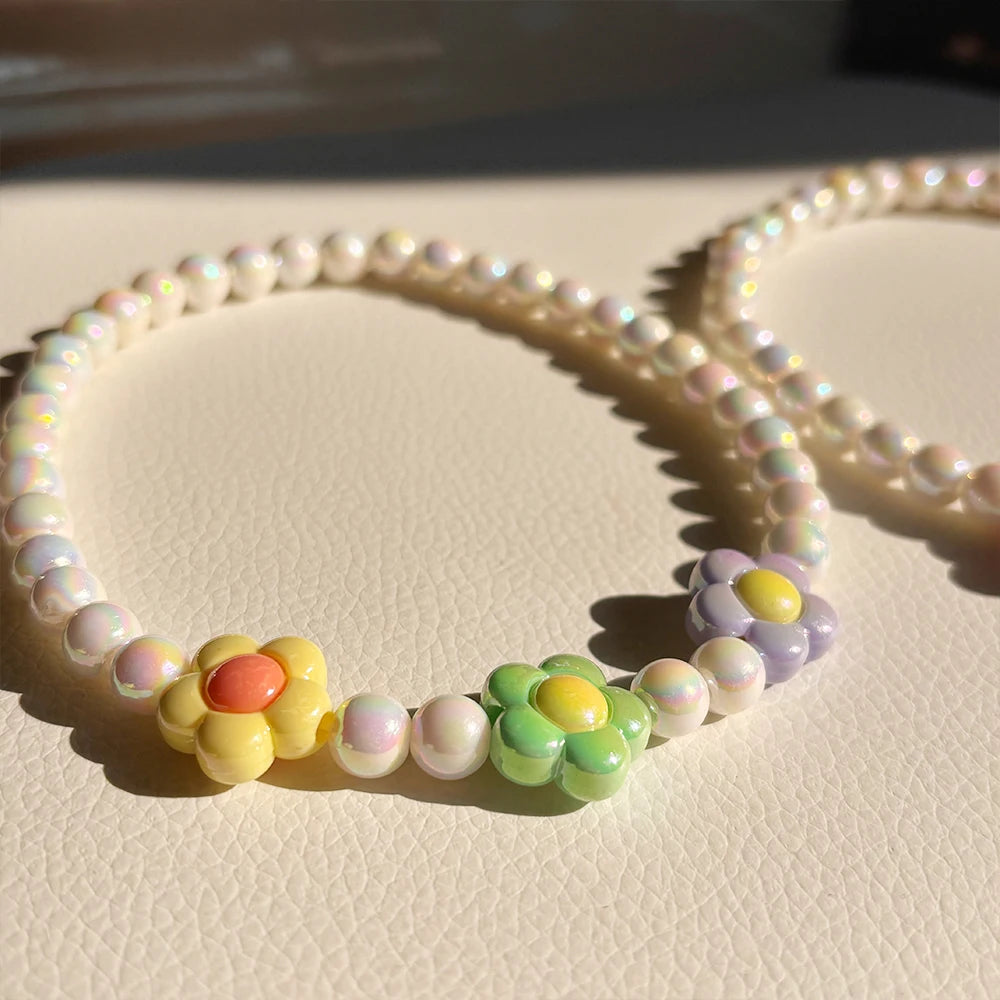 A set of pastel floral beaded necklaces featuring yellow, pink, and purple beads.