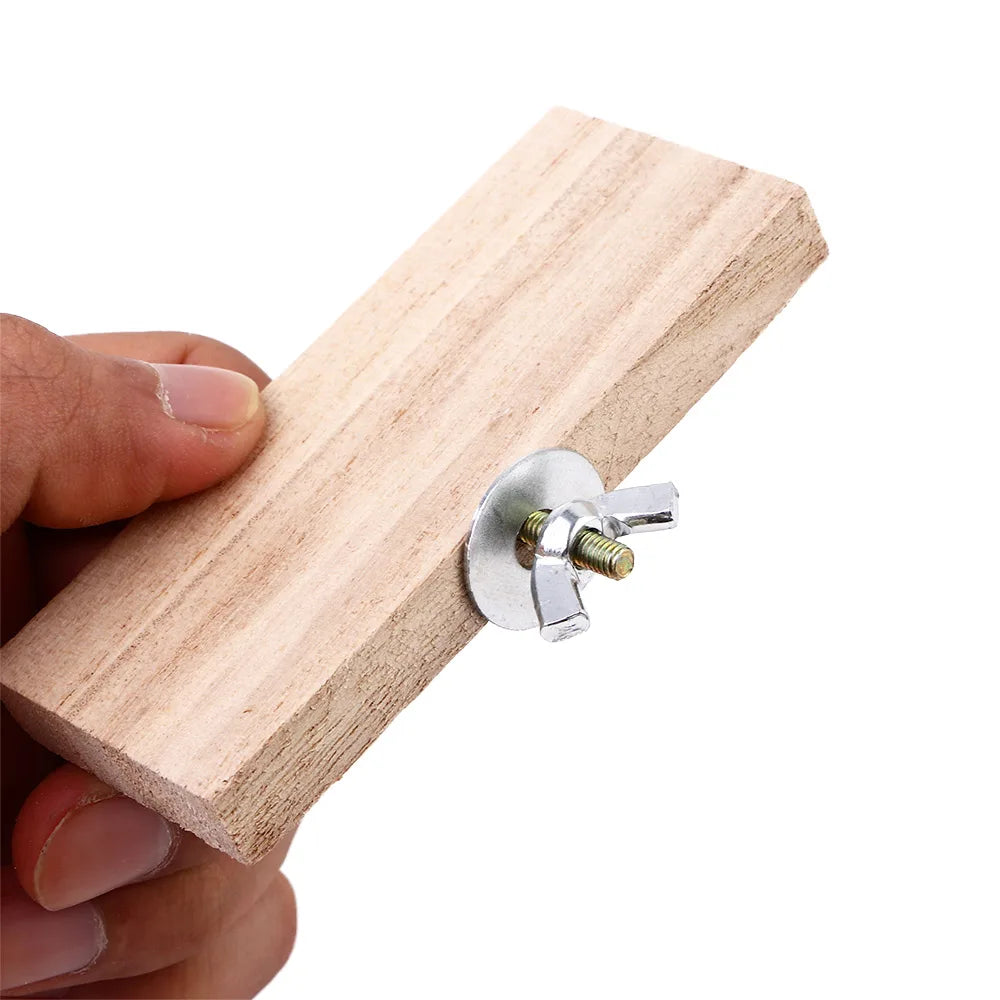 A hand holds a natural wood platform stand with a metal mounting plate and screw.