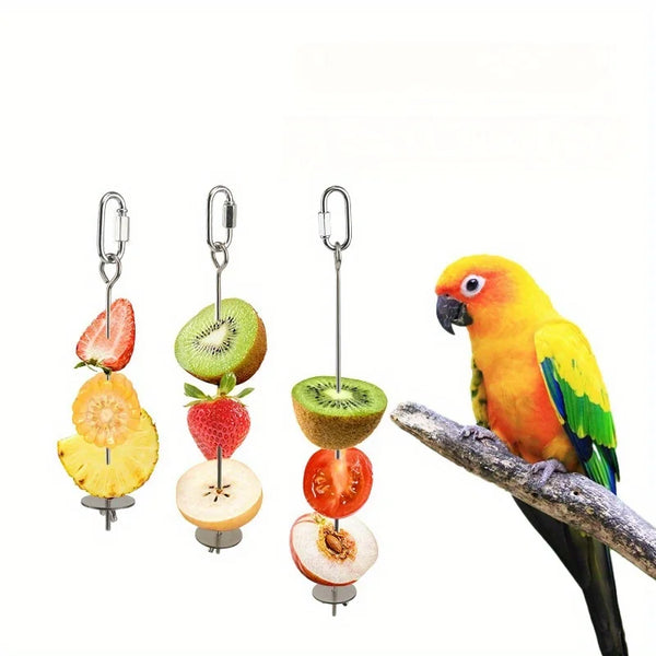 A stainless steel parrot feeder displaying various fresh fruits and vegetables like strawberries, kiwi, and citrus slices.