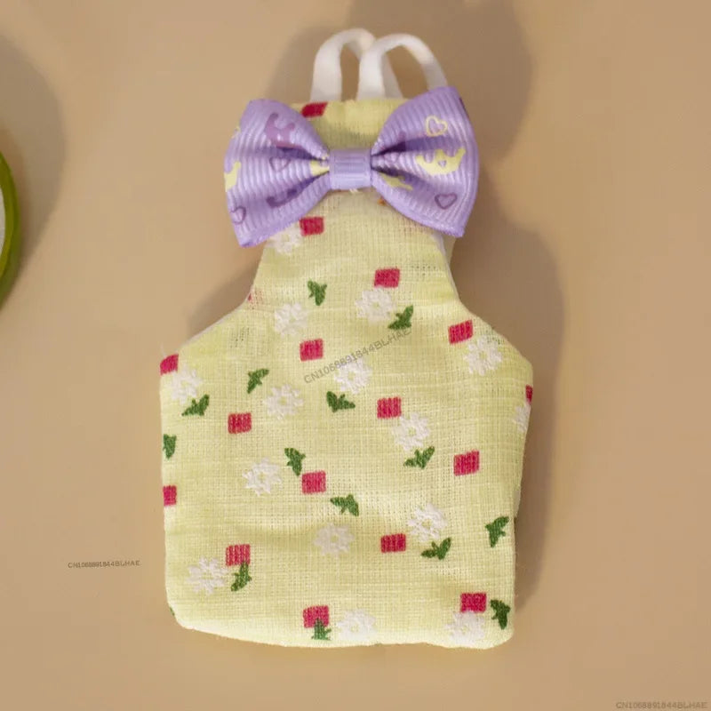 A yellow shirt with a purple bow tie and a pattern of small red and white floral shapes.