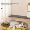 A gray cat is relaxing in a round, woven scratching post designed for furniture protection.