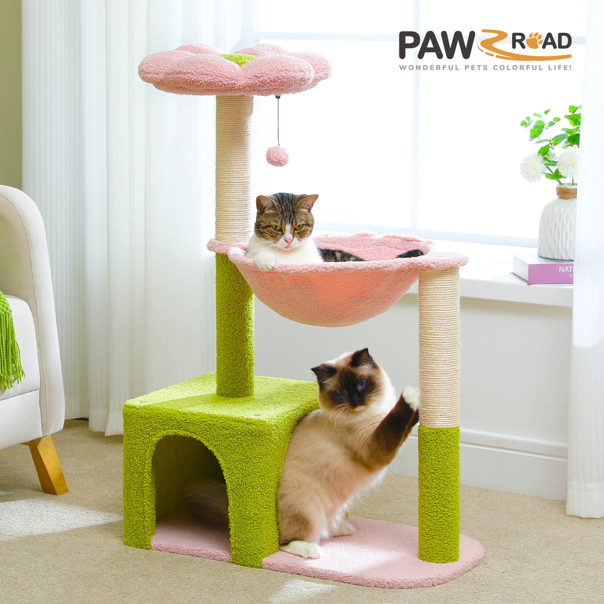 A pink and lime green decorative cat tree with sisal scratching posts, featuring a cat resting on a platform.