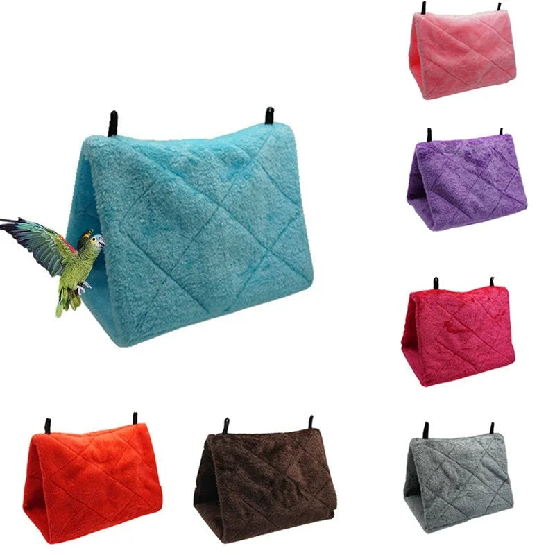 A collection of various colored cozy plush bird hammock nests in red, purple, teal, and gray.