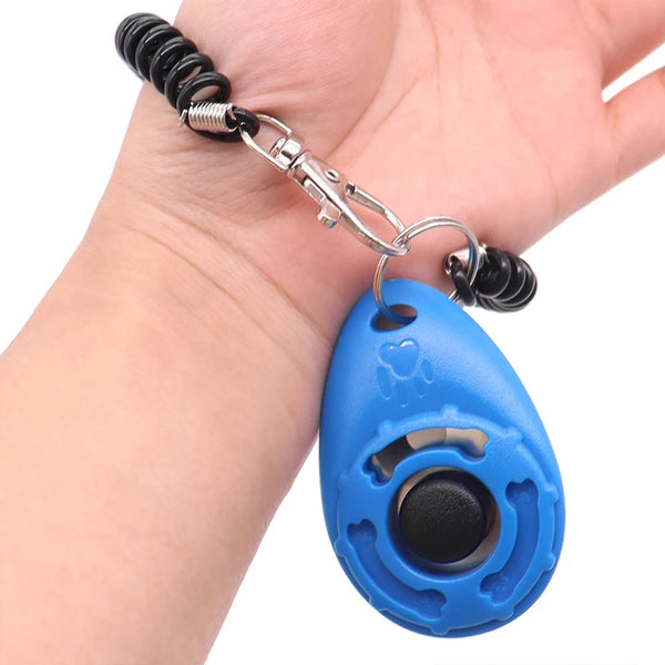 A hand is holding an adjustable pet training clicker for dogs and cats with a blue oval body and black clicker head.