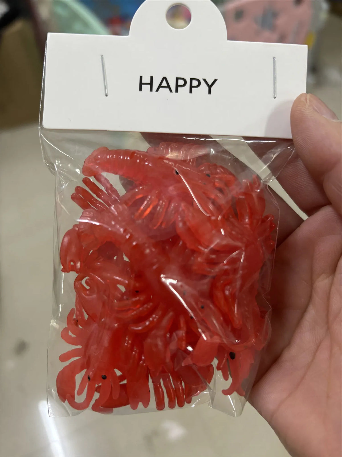 A clear plastic bag contains a set of ten bright red, soft rubber goldfish bath toys.