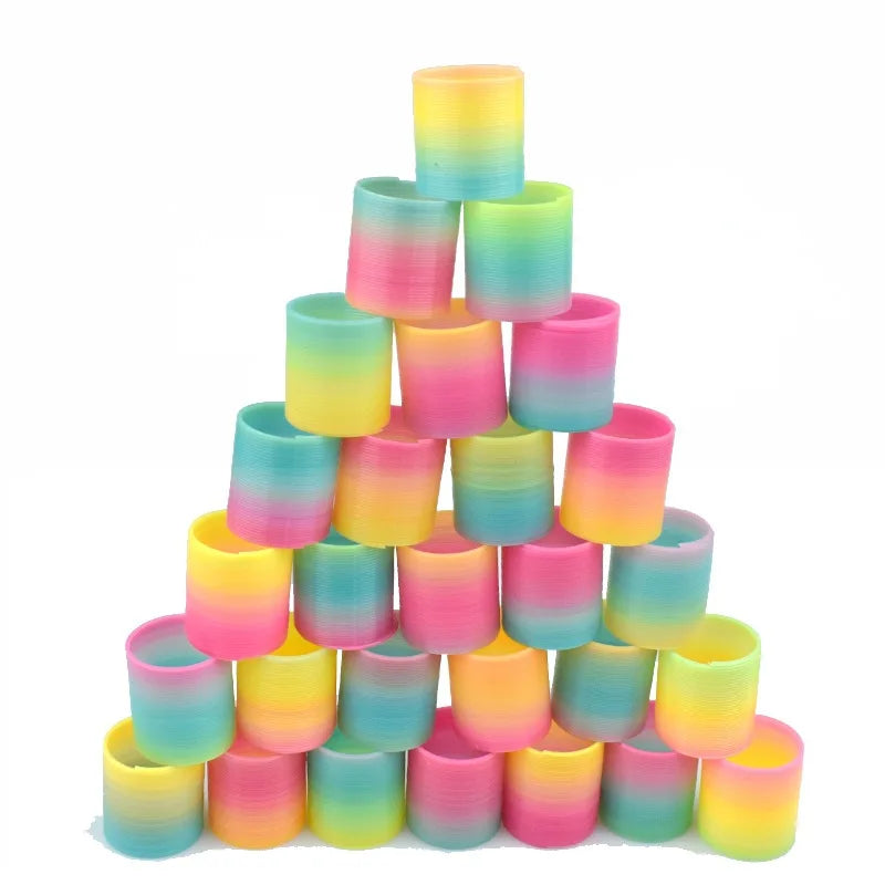 A pyramid stack of twelve colorful, translucent silicone spring toys in a rainbow gradient.