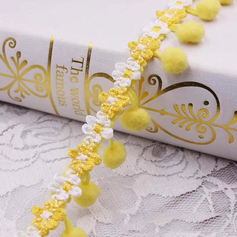 Yellow and white pearl pom pom fringe lace trim decoration on a book cover