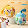 A yellow plush toy shaped like a panda with a bell attached, next to a blue plush ball and a dog.