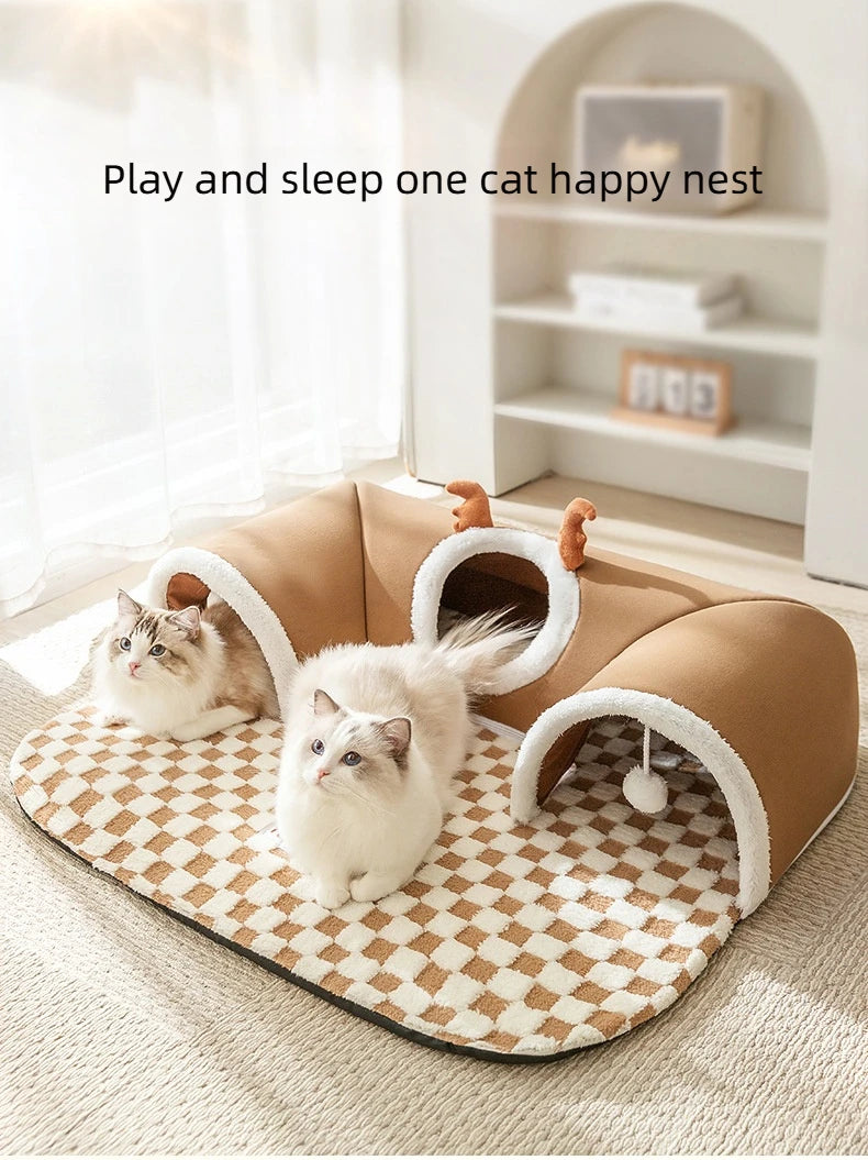 A beige plush cat bed with a reindeer tunnel for playing and sleeping, placed on a light rug.