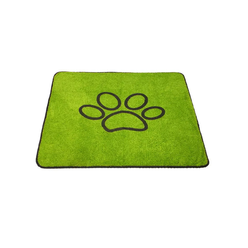 A bright green pet grass mat featuring a dark paw print design.