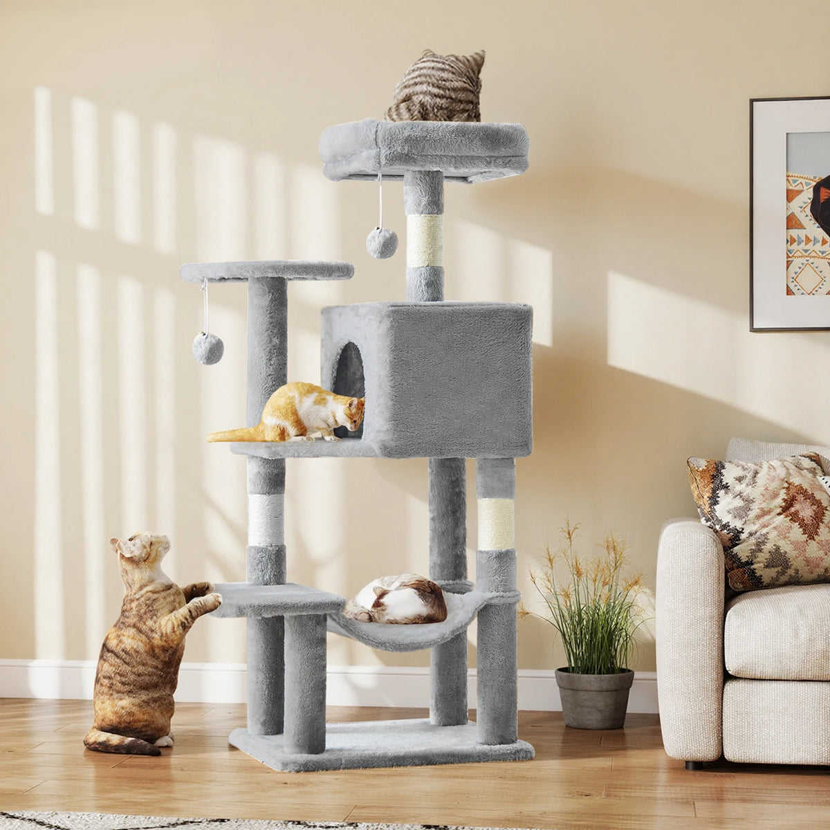 Tour à escalier grise à plusieurs niveaux avec accents de corde de sisal et un petit chaton tabby assis au niveau inférieur.