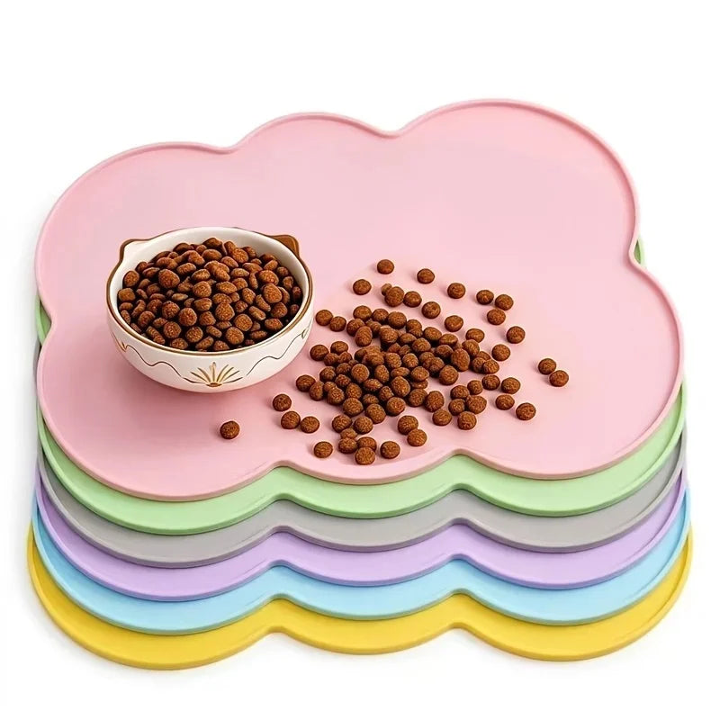 A pink silicone pet feeding mat with raised edges holding brown pet food pellets.