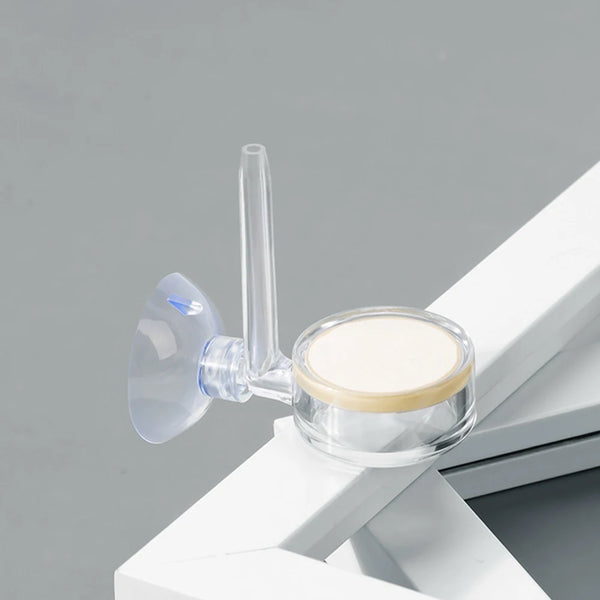 A clear glass CO2 diffuser with a nozzle is shown resting on a white platform.