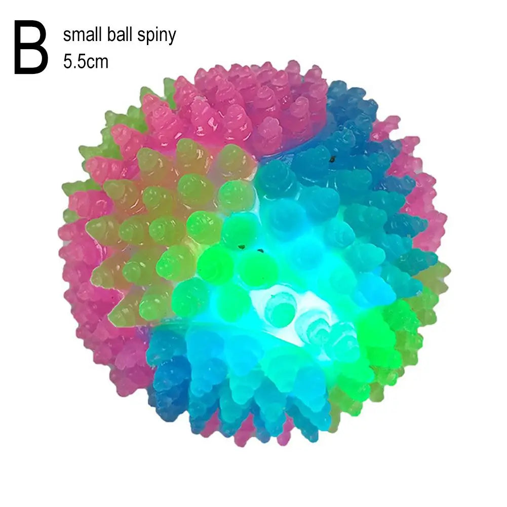 A small ball spiny object glowing with multiple colors including pink, green, and blue.