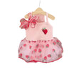 Pink strawberry princess pet dress with a ruffled skirt and bow, displayed on a hanger.