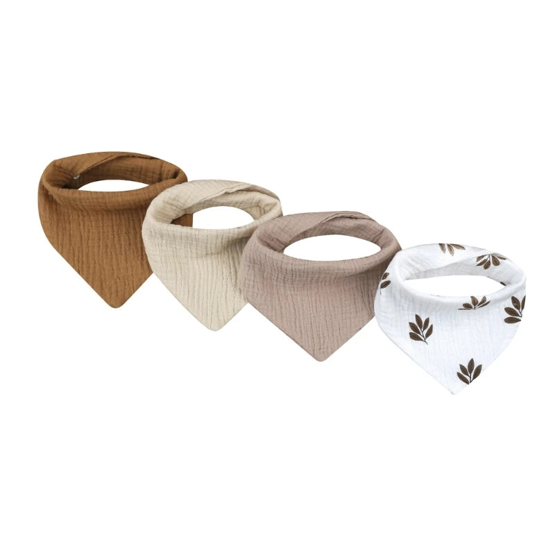 A set of four cotton baby bibs in various neutral tones and white with leaf prints for newborns