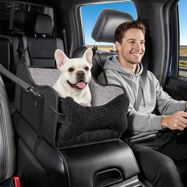 A smiling man sits in a car seat with a small white dog resting on the seat.