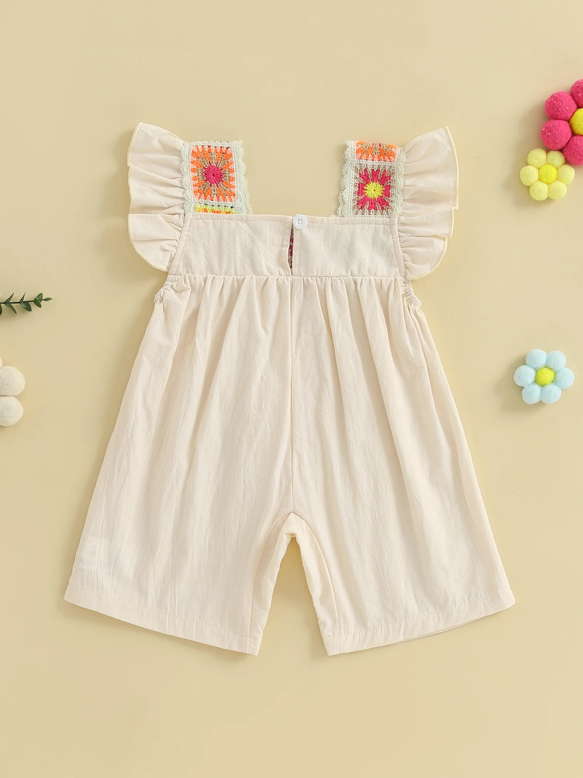 A light pink floral embroidery toddler romper for girls with ruffled sleeves and decorative trim.