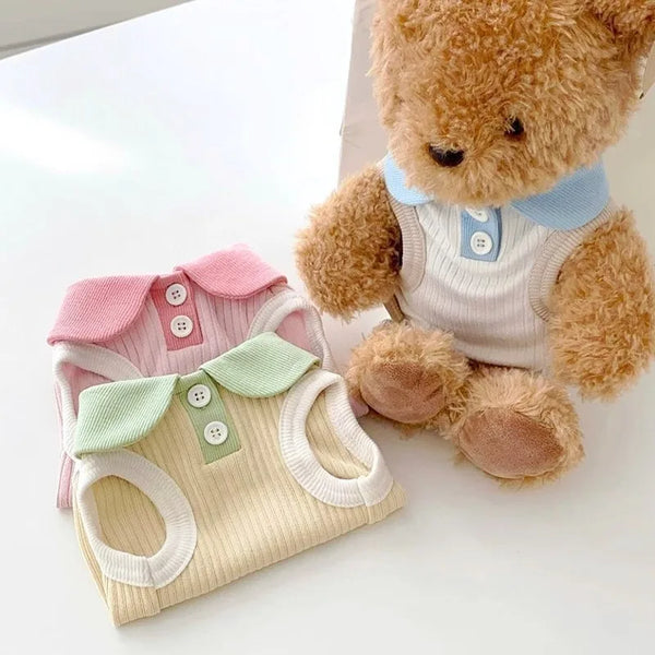 A fluffy brown teddy bear is sitting next to a light beige cooling pet polo shirt for small dogs and cats.