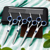 A set of professional stainless steel pet grooming scissors and a comb resting on a black case.