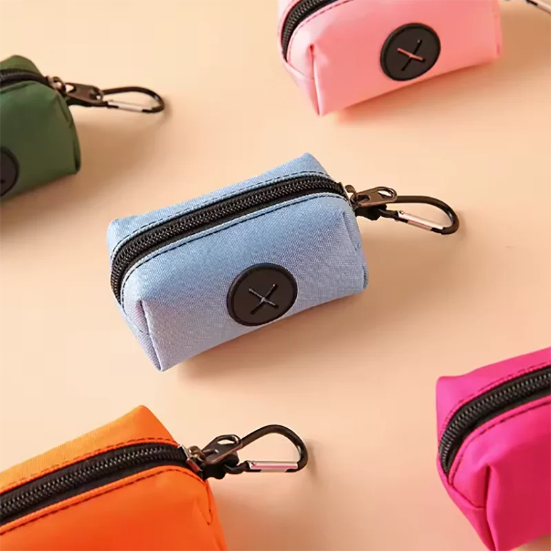 A collection of small fabric pouches and bags in various pastel colors like pink, mint green, and blue, featuring metal clasp