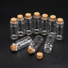 A collection of ten mini glass bottles with cork stoppers arranged on a dark surface.