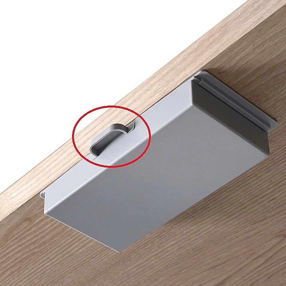 A silver under desk drawer organizer with a dust-proof cover is shown resting on a wooden surface.