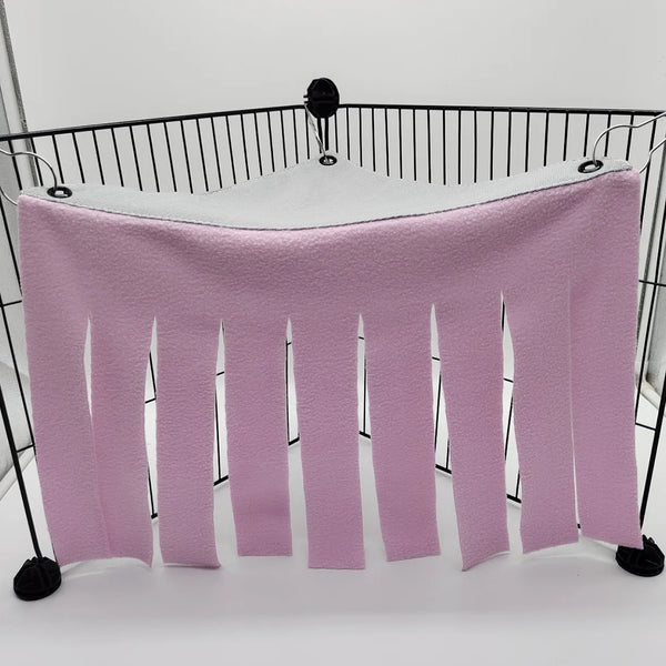 A pink plush pet hammock and hideaway with dangling strips suspended from a black metal frame.