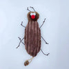 A plush toy resembling a cockroach with antennae and a red mouth, made for cats.
