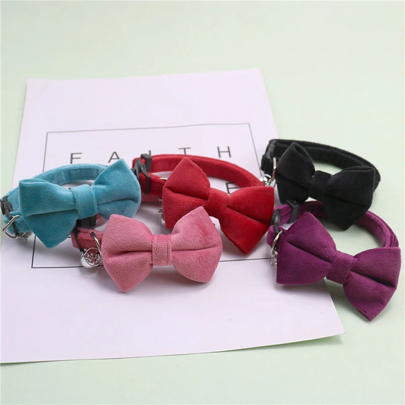 A collection of plush velvet pet collars featuring various colored bows including teal, red, black, and purple.