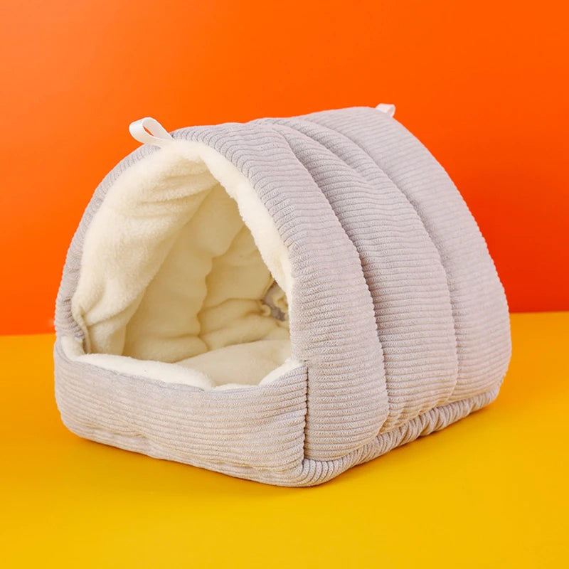 A light gray, quilted cotton bird nest with an open entrance showing a fluffy white lining.