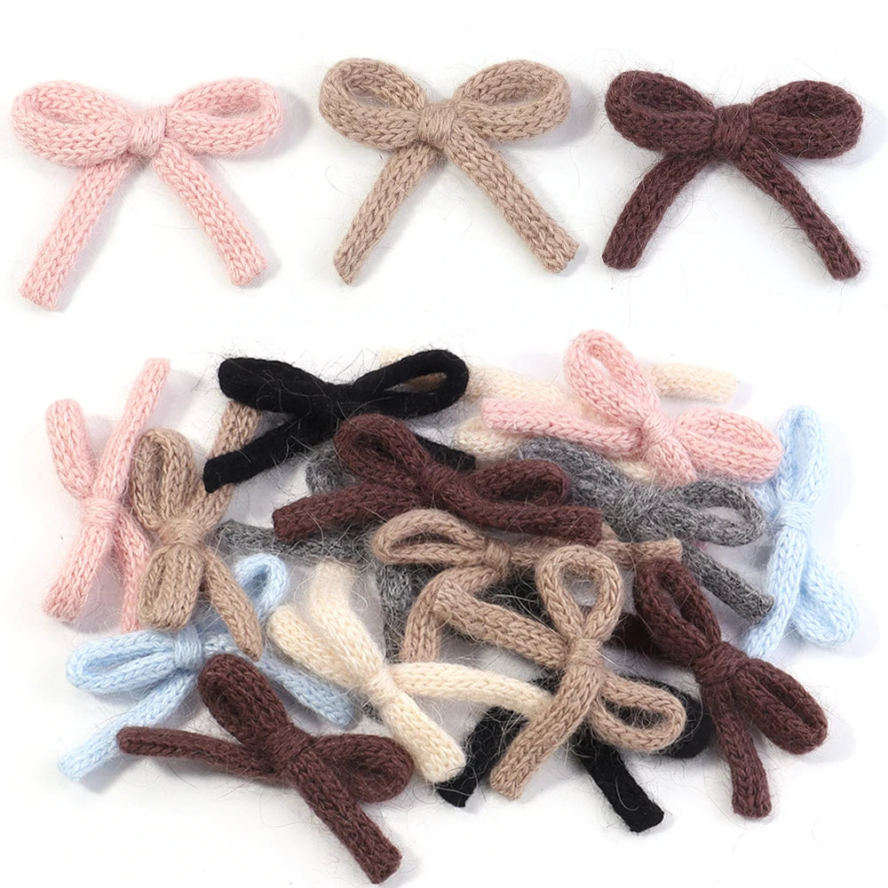 A set of six handmade knitted cotton bows in various shades including pink, beige, brown, gray, and blue.