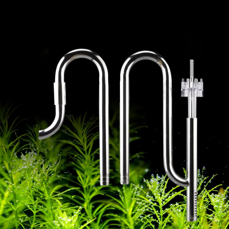 Kit de raccord aquarium en acier inoxydable avec tuyaux et raccords entouré de plantes aquatiques vertes
