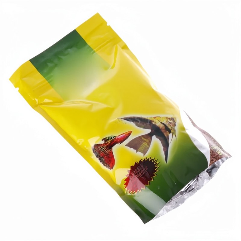 Gelbe und grüne Packung mit schwimmendem Futter für Aquarium: Tropische Guppy und Laternenfische.