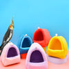 A collection of colorful, soft fabric bird hammocks or nests in pink, blue, orange, and yellow.