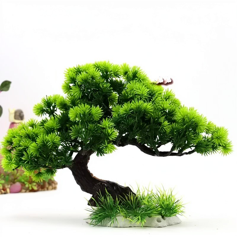 A miniature bonsai tree with bright green foliage is set on a light rock for aquarium or landscape decor.