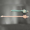 Two floral breakaway cat collars, one mint green and one pink, with bells.
