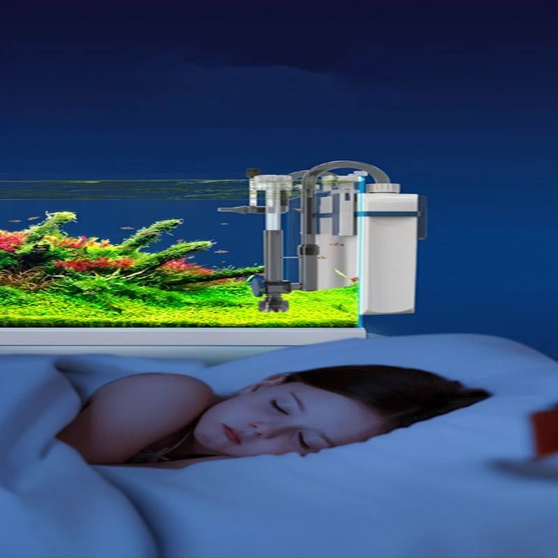 A wall-mounted aquarium filter is shown next to a fish tank, with a person lying down in the foreground.